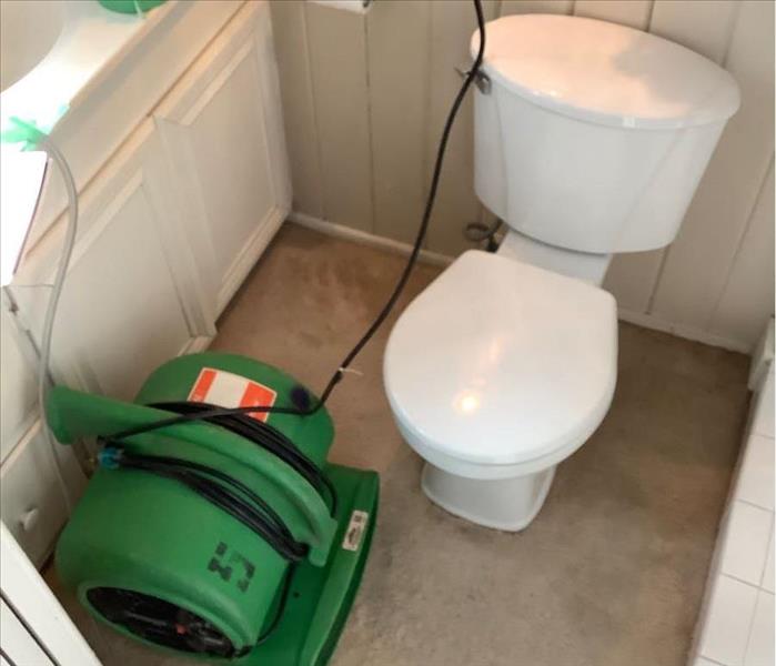 a toilet with green drying equipment next to it