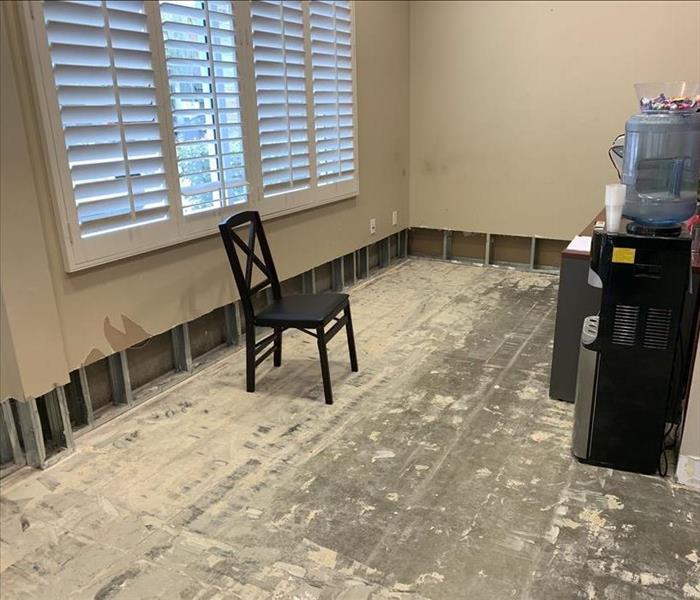 Room with flood cuts and a chair on the floor.