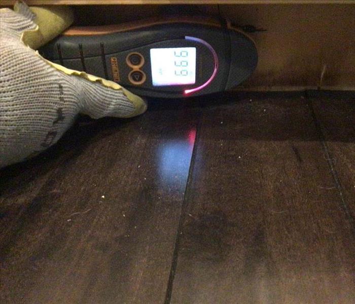 Moisture detection device measuring baseboards.
