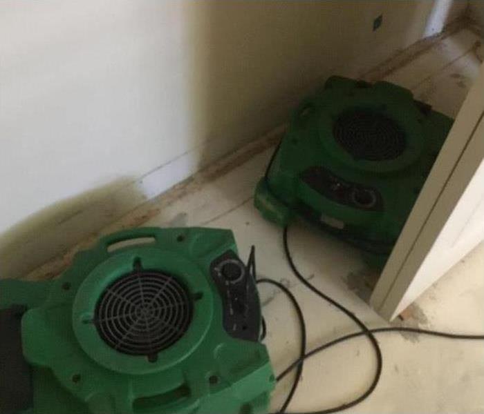 Two air movers drying damaged area in a home