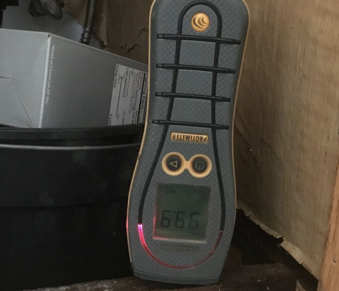 a moisture meter set up in a cabinet space